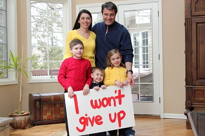 Katie Cancro and her family with a sign reading: "I won't give up"