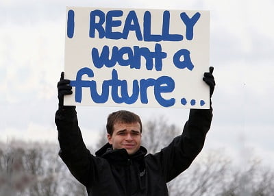 Young man holding sign reading: I really want a future...